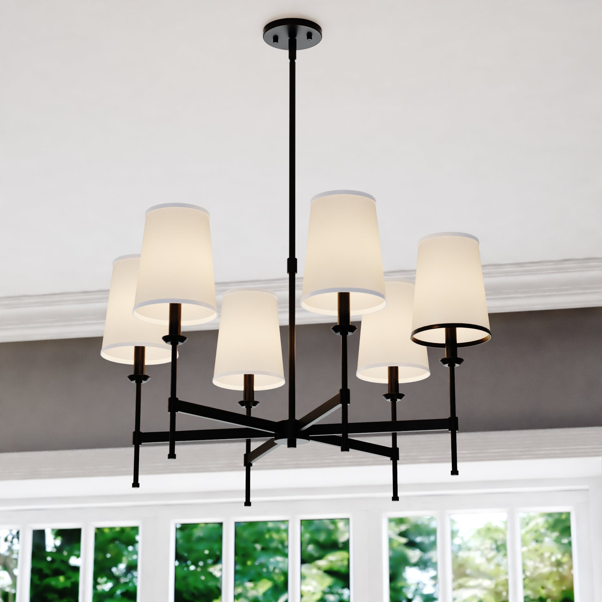 Front view of the Camden 30-inch 6 Light Chandelier featuring white linen fabric shades and matte black frame in a bright room with large windows