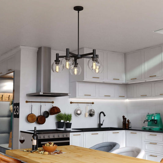 Marshall 27-inch 5 Light chandelier displayed in a modern kitchen, featuring matte black arms with clear glass globes and Edison-style bulbs.