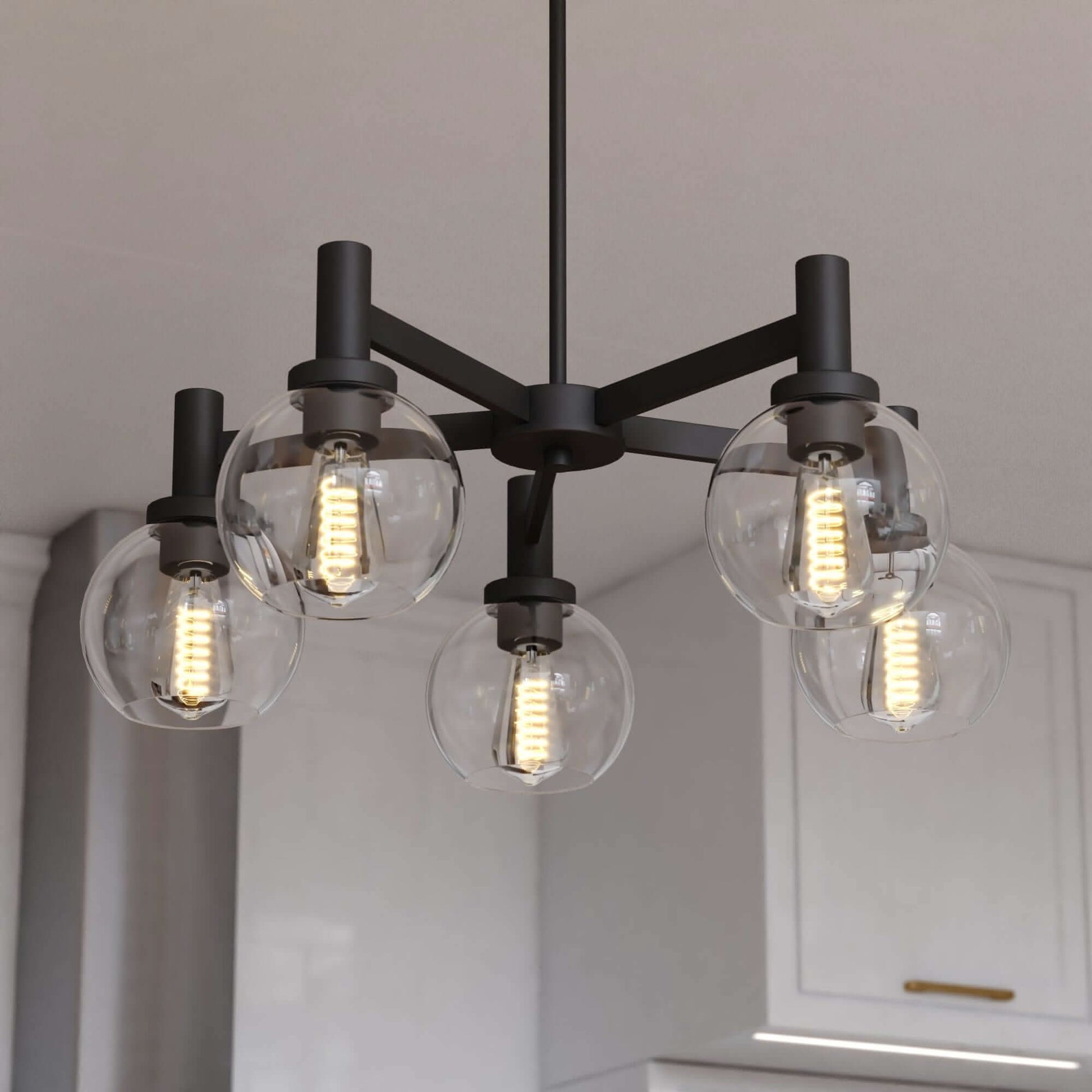 Close-up view of the Marshall 27-inch 5 Light chandelier featuring matte black arms with clear round glass globes and Edison-style LED bulbs.