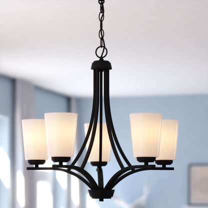 Front view of the River Grove 24.75-inch wide 5-light chandelier in matte black, shown in a lifestyle installation highlighting frosted glass shades and curved arms