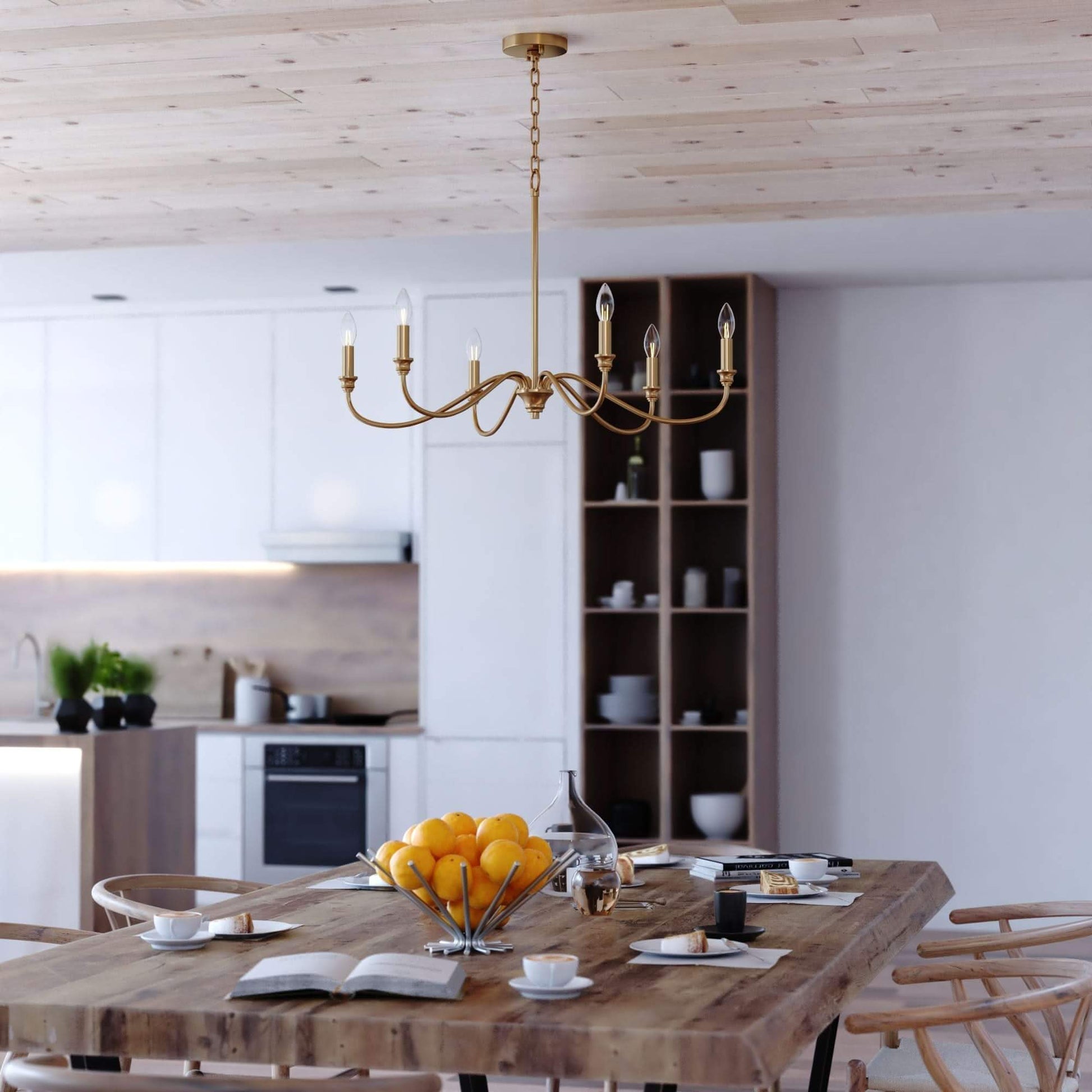 Annabelle 30-inch wide 6-light chandelier in satin brass featuring a steel frame with gracefully curved arms, candelabra-style bulbs, and chain suspension, shown installed in a styled interior setting.